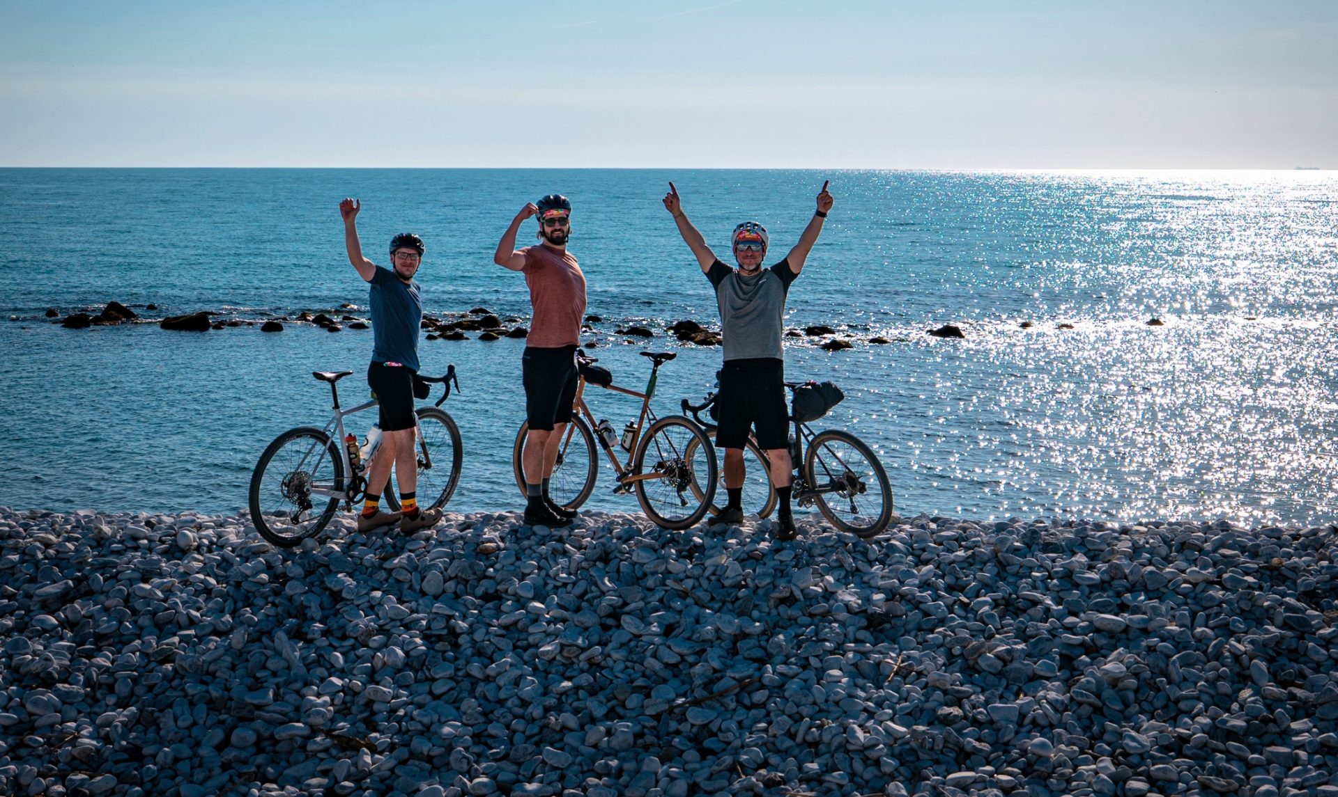 Tre ciclisti a Marina di Pisa, con il mare sullo sfondo